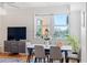 Dining area features a modern table, a cabinet, and a large window with lovely green plants at 750 N Tamiami Trl # 407, Sarasota, FL 34236