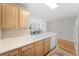 An open kitchen with light wood cabinetry, a white countertop island, and bright natural light at 750 N Tamiami Trl # 407, Sarasota, FL 34236