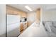 Efficient kitchen with wooden cabinets, white appliances, and a view of the living area at 750 N Tamiami Trl # 407, Sarasota, FL 34236