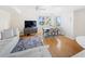 Bright living room with hardwood floors, a modern entertainment center, and a cozy dining area at 750 N Tamiami Trl # 407, Sarasota, FL 34236