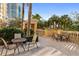 Patio area features ample outdoor seating with palm trees and high rise building at 750 N Tamiami Trl # 407, Sarasota, FL 34236