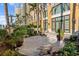 Beautifully landscaped backyard patio with large planters, bench, and high-rise building at 750 N Tamiami Trl # 407, Sarasota, FL 34236
