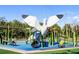 Outdoor playground with unique bird slide, benches, and green landscaping at 750 N Tamiami Trl # 407, Sarasota, FL 34236