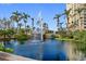 Water fountain feature in a large pond area with a walking path and lush vegetation at 750 N Tamiami Trl # 407, Sarasota, FL 34236