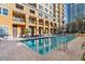 Relaxing pool has deck seating and overlooks the high rise building with balconies at 750 N Tamiami Trl # 407, Sarasota, FL 34236