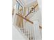 Classic white staircase featuring wood handrail accents and natural light from a window at 750 N Tamiami Trl # 407, Sarasota, FL 34236