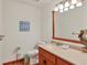 Light filled bathroom offers a wood vanity, framed mirror, and decorative beach themed art at 7717 27Th W Ave, Bradenton, FL 34209