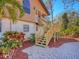 Exterior view of the stairs leading to the front door, with new tropical landscaping and a brick path at 7717 27Th W Ave, Bradenton, FL 34209