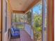 View of covered porch with wood floors, white railing and comfortable seating with patterned pillows at 7717 27Th W Ave, Bradenton, FL 34209
