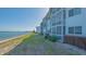 Exterior shot showcasing water views, lush lawn, and coastal condo architecture at 775 John Ringling Blvd # 3, Sarasota, FL 34236