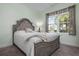 Relaxing bedroom featuring a decorative headboard, cozy bed, and a window with view of outdoor foliage at 7750 Ridgelake Cir, Bradenton, FL 34203