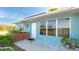 Close-up of a blue single-story home's entrance, with a red brick planter bed at 8003 Herbison Ave, North Port, FL 34287
