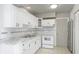 Clean white kitchen with ample cabinet space and modern appliances, with a stainless steel refrigerator at 8003 Herbison Ave, North Port, FL 34287