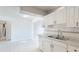 Well-lit kitchen with white cabinetry, marble countertops, and a functional layout at 8003 Herbison Ave, North Port, FL 34287