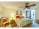 Bright bedroom with a ceiling fan, accent chair and sliding glass doors to the outdoor balcony at 8767 Midnight Pass Rd # 506-F, Sarasota, FL 34242