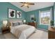 Inviting bedroom with bright turquoise walls, a ceiling fan, and an oversized window with lots of natural light at 8850 Christie Dr, Largo, FL 33771