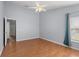 Bedroom featuring a ceiling fan, wood floors, and a window with curtains at 8850 Christie Dr, Largo, FL 33771