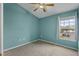 A charming bedroom with a ceiling fan, a sunlit window, and calming light blue colored walls at 8850 Christie Dr, Largo, FL 33771