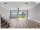 Bright living room with wood floors, a ceiling fan, and windows offering an outdoor view at 8850 Christie Dr, Largo, FL 33771