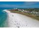 Aerial view of a beach with beachgoers, white sand, and clear water at 9074 Midnight Pass Rd # 11, Sarasota, FL 34242