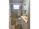 A cozy bathroom with a shower with translucent doors, toilet and neutral vanity with a sink at 935 Shasta Rd, Venice, FL 34293