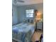 A cozy bedroom with a window, stylish decor, and a bed with a patterned quilt at 935 Shasta Rd, Venice, FL 34293