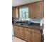 A view of the kitchen sink and counter area in a functional kitchen with wooden cabinets at 935 Shasta Rd, Venice, FL 34293