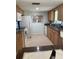A functional kitchen featuring wooden cabinets, neutral countertops and flooring and standard white appliances at 935 Shasta Rd, Venice, FL 34293