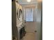 Laundry room with stacked washer and dryer, window, and door to the outside at 935 Shasta Rd, Venice, FL 34293