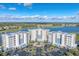 Scenic aerial shot of condo buildings with a pool, surrounded by lush landscaping, near a lake and a golf course at 10520 Boardwalk Loop # 504, Lakewood Ranch, FL 34202
