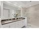 Bright bathroom features dual sinks, white cabinetry, and glass shower at 10520 Boardwalk Loop # 504, Lakewood Ranch, FL 34202