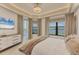 Bright main bedroom with balcony access, water views, and a large dresser at 10520 Boardwalk Loop # 504, Lakewood Ranch, FL 34202