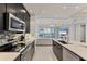 Well-equipped kitchen with stainless appliances and view into the living area with water views at 10520 Boardwalk Loop # 504, Lakewood Ranch, FL 34202
