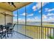 Screened lanai features beautiful lake views, table, and seating at 10520 Boardwalk Loop # 504, Lakewood Ranch, FL 34202