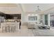 Open-concept living space with a modern kitchen, sleek island, comfortable sofa, and access to an outdoor balcony at 10520 Boardwalk Loop # 504, Lakewood Ranch, FL 34202