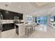 Open living space featuring tile floors, a kitchen island, and sliding glass doors to the lanai at 10520 Boardwalk Loop # 504, Lakewood Ranch, FL 34202