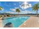 Beautiful community pool with lounge chairs and tropical landscaping under a bright sky at 10520 Boardwalk Loop # 504, Lakewood Ranch, FL 34202