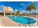 Beautiful community pool area with sun loungers, seating, and a lush tropical landscape on a sunny day at 10520 Boardwalk Loop # 504, Lakewood Ranch, FL 34202