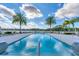 Inviting community pool with lounge chairs and tropical palm trees under a bright sky at 10520 Boardwalk Loop # 504, Lakewood Ranch, FL 34202