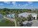 Community pool and clubhouse with a lake view surrounded by lush tropical landscaping at 10520 Boardwalk Loop # 504, Lakewood Ranch, FL 34202