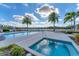 Community pool area featuring a pool and a relaxing hot tub, surrounded by lush landscaping at 10520 Boardwalk Loop # 504, Lakewood Ranch, FL 34202