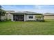Expansive backyard with screened lanai, lush green lawn, and exterior view of the home at 11050 Sandhill Preserve Dr, Sarasota, FL 34238