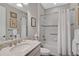 Well-lit bathroom with a shower-tub combo, white tiled walls and neutral accents at 11050 Sandhill Preserve Dr, Sarasota, FL 34238