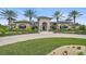 Elegant clubhouse exterior featuring a grand entrance, lush landscaping, and paved driveway at 11050 Sandhill Preserve Dr, Sarasota, FL 34238