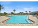 The community pool is surrounded by lounge chairs and umbrellas, with a view of the clubhouse at 11050 Sandhill Preserve Dr, Sarasota, FL 34238