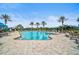 A stunning community pool is surrounded by lounge chairs and palm trees on a sunny day at 11050 Sandhill Preserve Dr, Sarasota, FL 34238