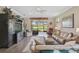 Inviting living room featuring a large sectional sofa, entertainment center, and access to the screened lanai with lake views at 11050 Sandhill Preserve Dr, Sarasota, FL 34238