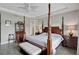 Traditional primary bedroom features a four-poster bed, wood floors, and decorative ceiling fan at 11050 Sandhill Preserve Dr, Sarasota, FL 34238
