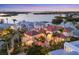 Aerial view of luxury waterfront homes, including tile roofs, surrounded by lush tropical landscaping and the bay at 1137 N Lake Shore Dr, Sarasota, FL 34231