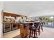 Basement bar area with extensive shelving, seating, and a view of the outdoor patio at 1137 N Lake Shore Dr, Sarasota, FL 34231